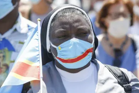 A nun wears a protective mask in the colors of the Democratic Republic of the Congo, during the Angelus prayer celebrated by Pope Francis from the window of his studio overlooking St. Peter’s Square at the Vatican