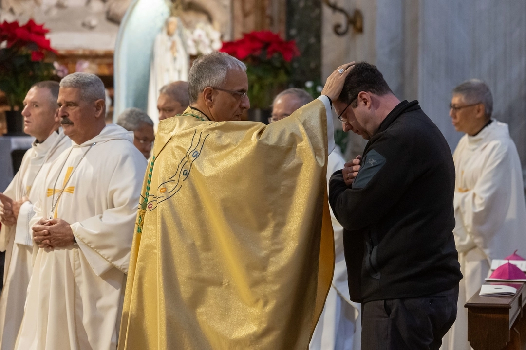 Bishop Bruce Myers, Anglican bishop of Québec, receives a blessing during a Catholic Mass at the IARCCUM Summit