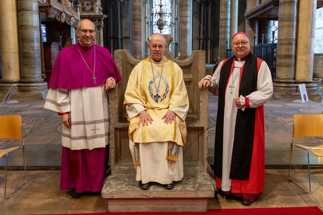Archbishop of Canterbury Justin Welby seated on the chair of his predecessor St Augustine, with IARCCUM co-chairs Archbishop Donald Bolen of Regina, Canada and Bishop David Hamid suffragan bishop in Europe