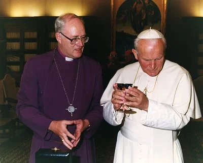 In 1992, Archbishop George Carey of Canterbury visited Pope John Paul II in Rome. In this picture, the archbishop gives a chalice to the pope, with the inscription, 'A sign of common prayer and hope for that gift of full communion which we know to be the will of our Lord.' The chalice was designed by <a href='https://www.foxsilver.net/' target='_blank'>Richard Fox</a>