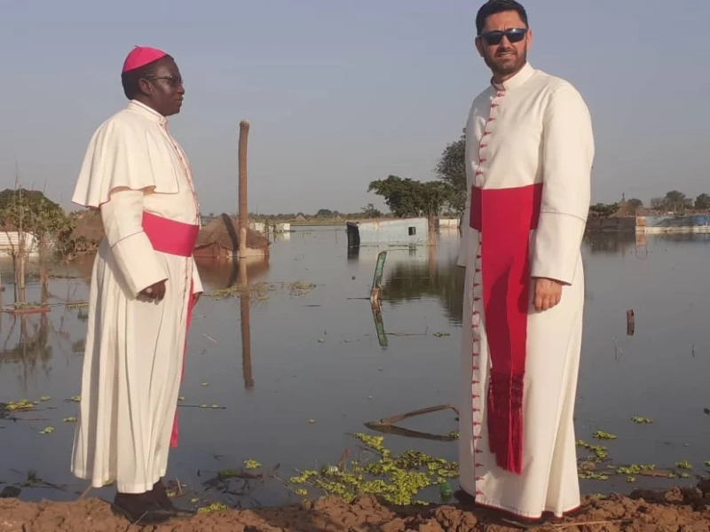 Bishop Stephen Nyodho Ador Majwok of Malakal, South Sudan, and Msgr. Ionut Paul Strejac, chargé d’affaires at the Vatican Embassy in South Sudan, stand in Bentiu, where ongoing flooding has submerged buildings, homes and markets