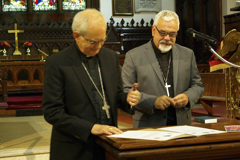 The Roman Catholic Bishop of Saint John, Robert Harris (left), and the Anglican Bishop of Fredericton, David Edwards, sign their joint declaration at St John’s Anglican Church in the New Brunwsick port city of Saint John on Monday