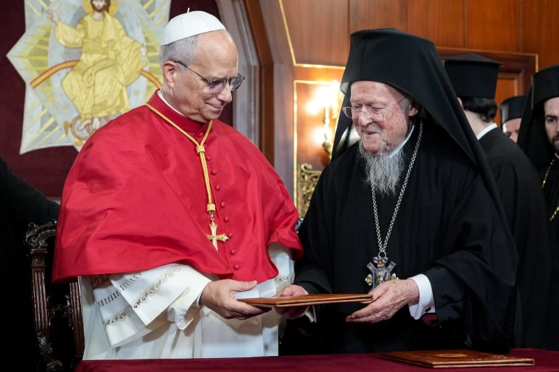 Pope Leo XIV and Ecumenical Patriarch Bartholomew of Constantinople hand each other copies of a joint declaration they signed at the end of a prayer service in the Patriarchal Cathedral of St. George in Istanbul