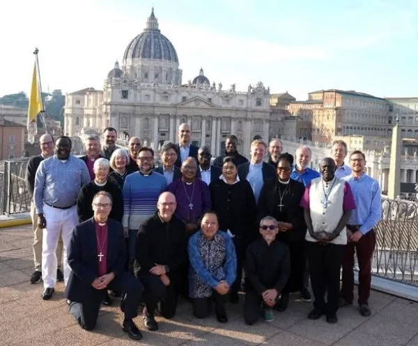 IASCUFO members, consultants, and Anglican Communion Office staff on a rooftop in Rome, with St Peter’s Basilica behind them, during their December gathering for prayer, reflection, and ecumenical engagement